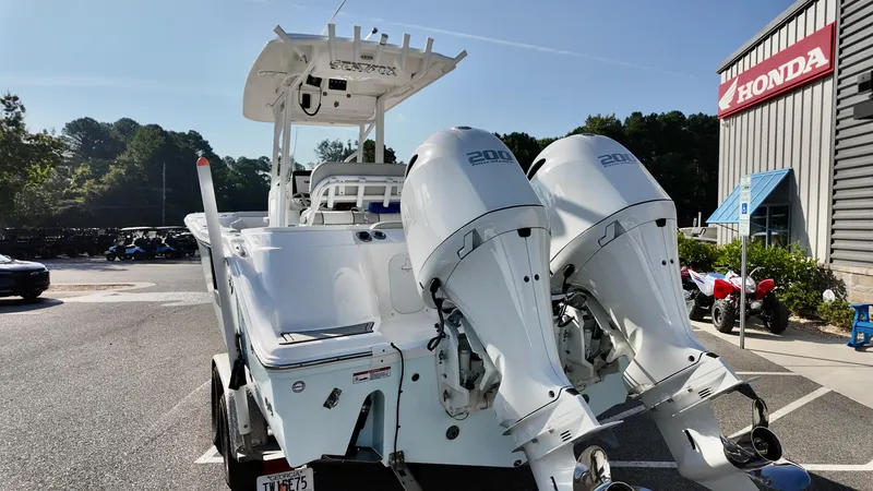 Slide: The Image of 2023 Sea Fox 268 Commander boat with dual engines parked near a Honda dealership. - 4