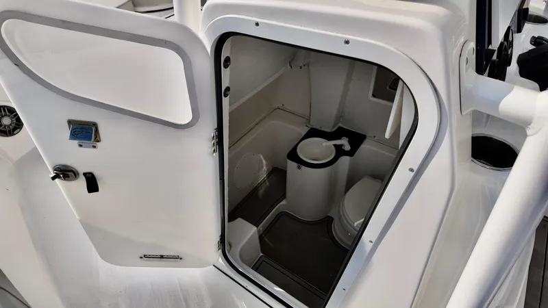 Slide: The Image of 2023 Sea Fox 268 Commander boat interior with open door revealing compact bathroom. - 9