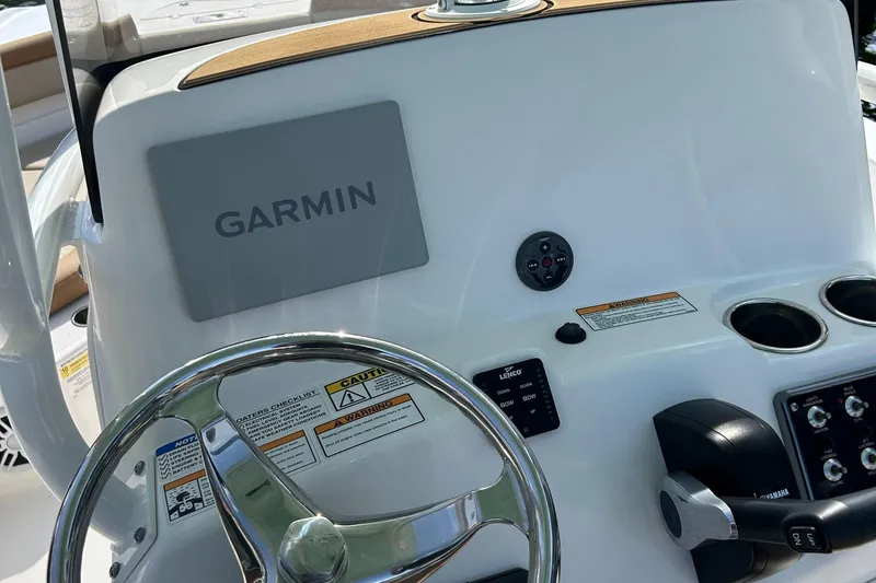 Slide: The Image of 2023 NauticStar 231 Hybrid boat seat with tan and cream upholstery, near water. - 14