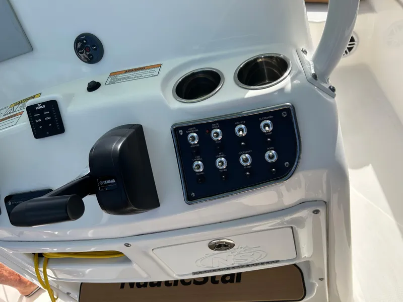 Slide: The Image of 2023 NauticStar 231 Hybrid boat storage compartment under teal canopy. - 17