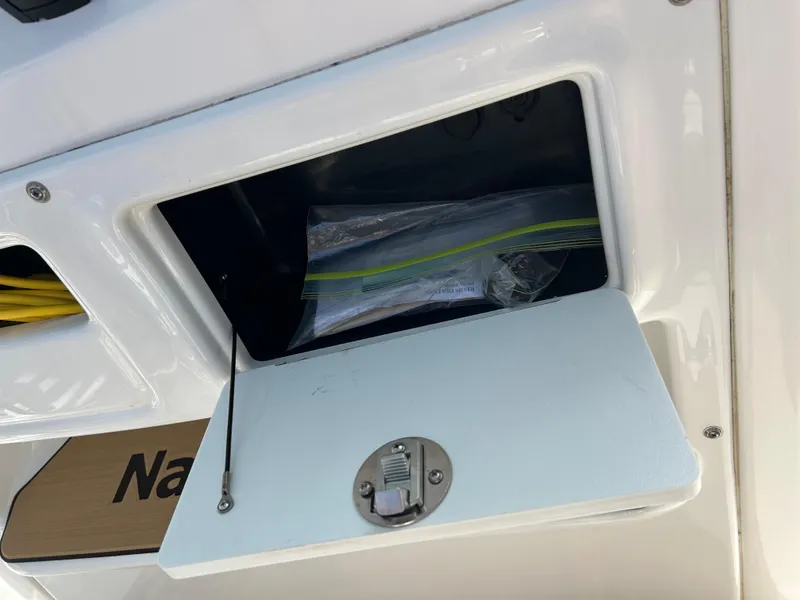 Slide: The Image of 2023 NauticStar 231 Hybrid boat console with storage compartment and safety equipment. - 18