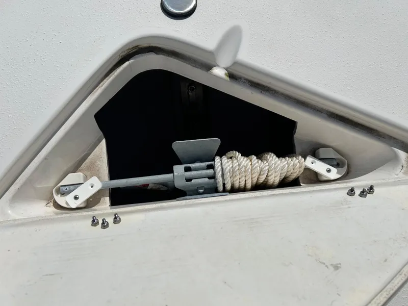 Slide: The Image of Anchor storage compartment on 2023 NauticStar 231 Hybrid boat, featuring coiled rope and secure fittings. - 30