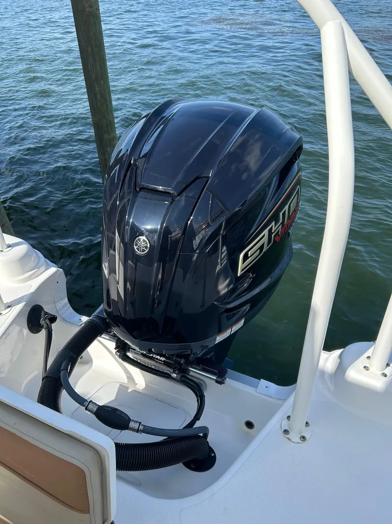 Slide: The Image of 2023 NauticStar 231 Hybrid boat interior detail with storage compartment and cup holders. - 49