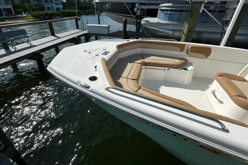 Slide: The Image of 2023 NauticStar 231 Hybrid boat interior with tan seating and steering console. - 5
