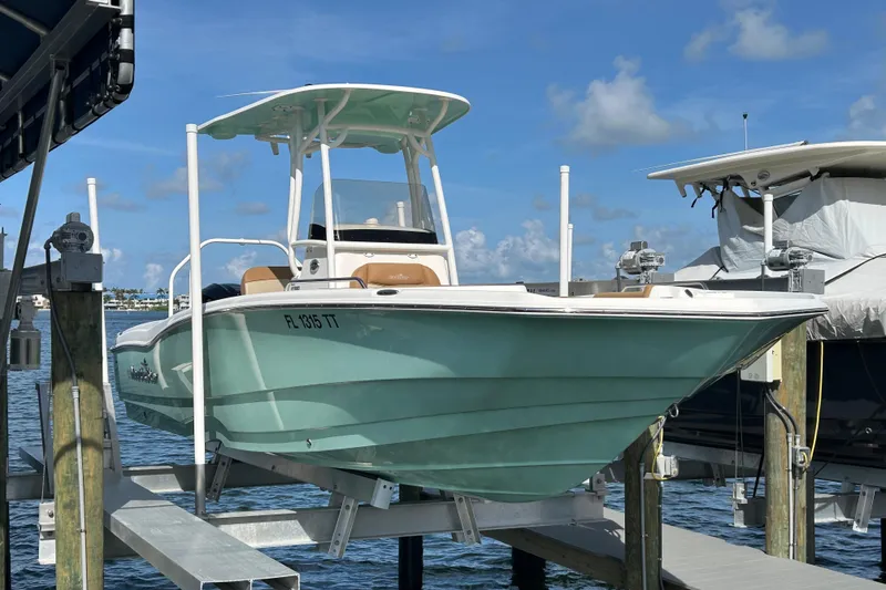 Slide: The Image of 2023 NauticStar 231 Hybrid boat on a lift by the water. - 57