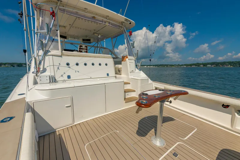 Slide: The Image of 1999 Ocean Yachts 48 Express boat deck with fishing setup, on a sunny day. - 21