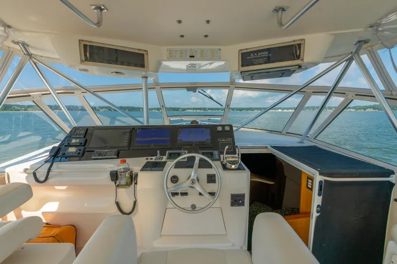 Slide: The Image of 1999 Ocean Yachts 48 Express helm with navigation equipment, overlooking serene waters. - 27