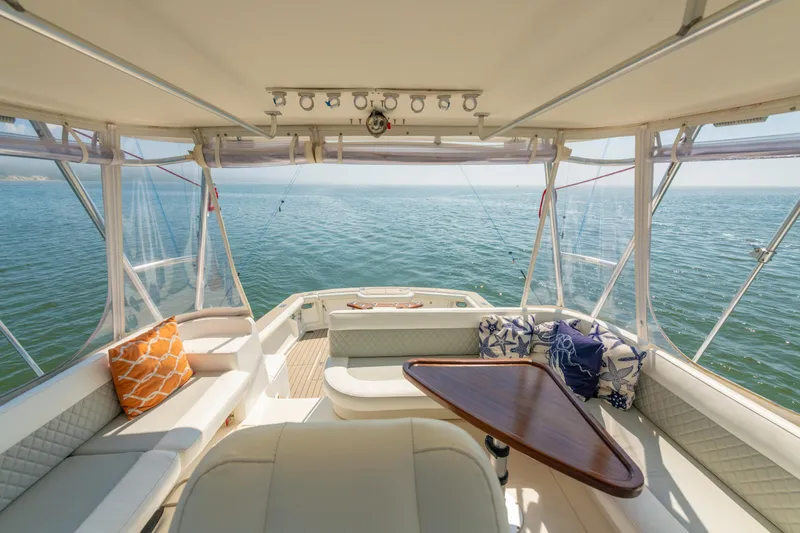 Slide: The Image of 1999 Ocean Yachts 48 Express interior with ocean view, featuring comfortable seating and decorative pillows. - 32