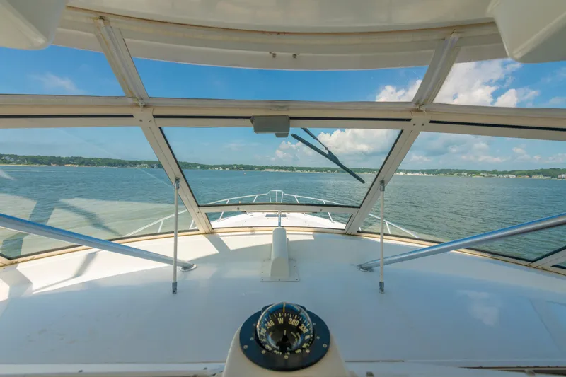 Slide: The Image of View from the helm of a 1999 Ocean Yachts 48 Express, overlooking calm waters. - 36