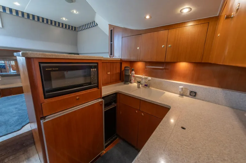 Slide: The Image of 1999 Ocean Yachts 48 Express kitchen with wood cabinets, microwave, and countertop. - 44