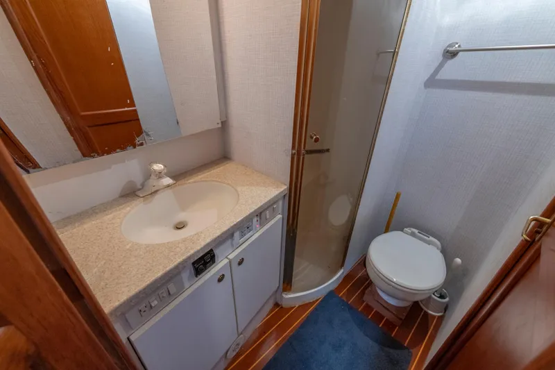 Slide: The Image of Bathroom interior of 1999 Ocean Yachts 48 Express, featuring sink, shower, and toilet. - 49