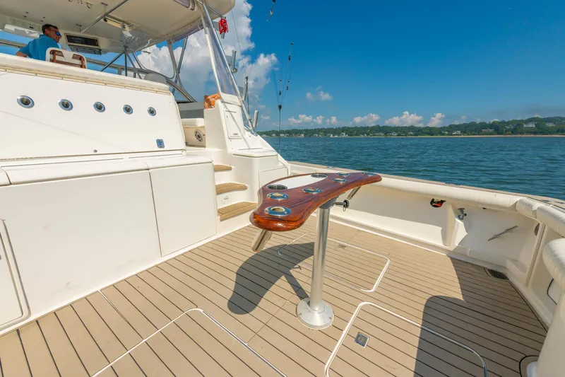 Slide: The Image of 1999 Ocean Yachts 48 Express boat deck with fishing rod holders, on a sunny day. - 11