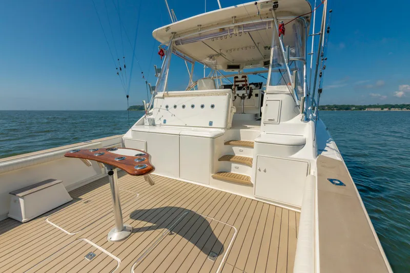 Slide: The Image of 1999 Ocean Yachts 48 Express boat deck with fishing setup on calm water. - 15