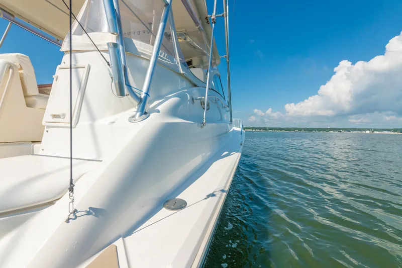 Slide: The Image of 1999 Ocean Yachts 48 Express cruising on calm waters under a clear blue sky. - 18