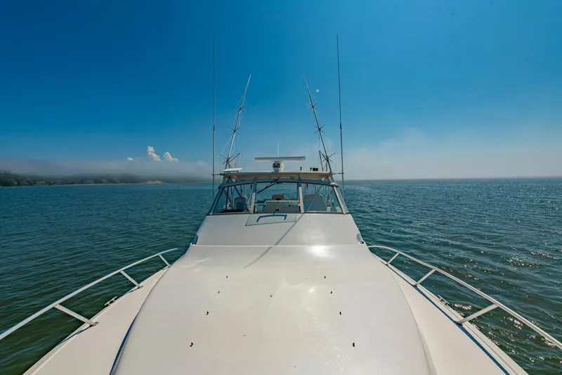 Slide: The Image of 1999 Ocean Yachts 48 Express cruising on open water under clear blue sky. - 19