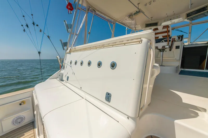 Slide: The Image of 1999 Ocean Yachts 48 Express boat deck with fishing rods, ocean view, and seating area. - 23