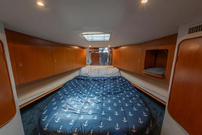 Slide: The Image of 1999 Ocean Yachts 48 Express cabin with cozy bed and wooden storage cabinets. - 47