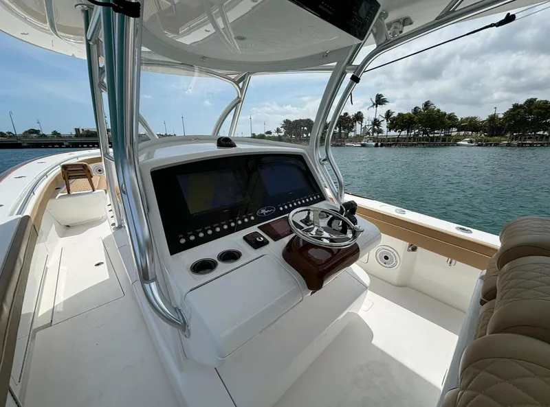 Slide: The Image of 2022 Valhalla Boatworks V-37 helm with modern controls, docked by scenic waterfront. - 5
