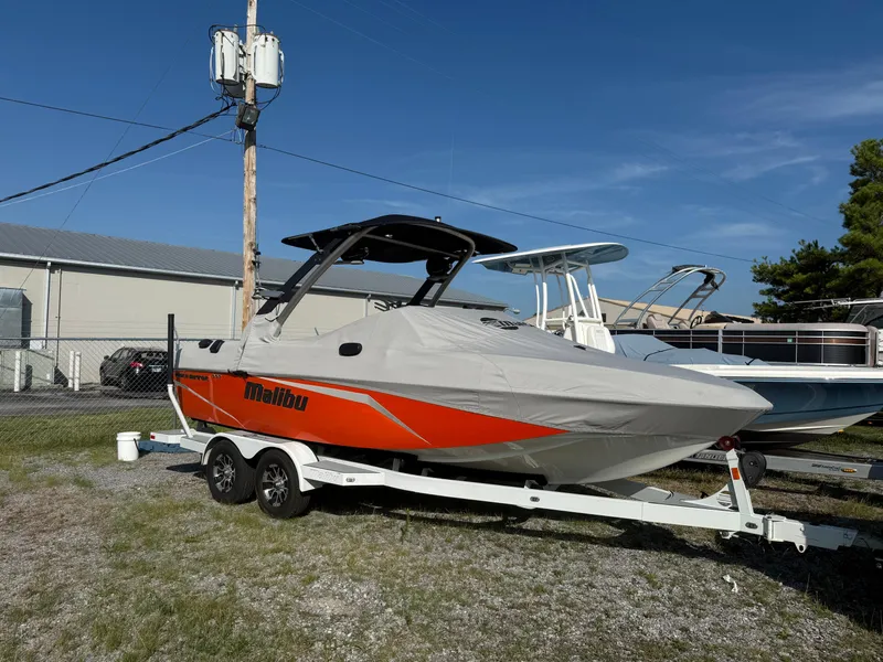 Slide: The Image of 2017 Malibu Wakesetter 21 VLX boat covered on trailer, parked outdoors. - 10