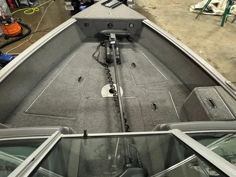 Slide: The Image of 2017 Lund 1850 Impact XS boat interior with carpeted deck and trolling motor. - 12