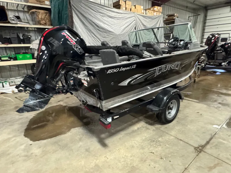 Slide: The Image of 2017 Lund 1850 Impact XS boat with Mercury engine in a garage setting. - 4