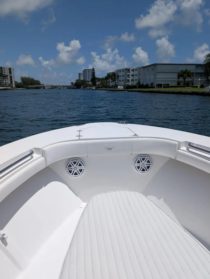 Slide: The Image of Bow view of 2016 Southport 272TE boat on a sunny day, with waterfront buildings. - 11