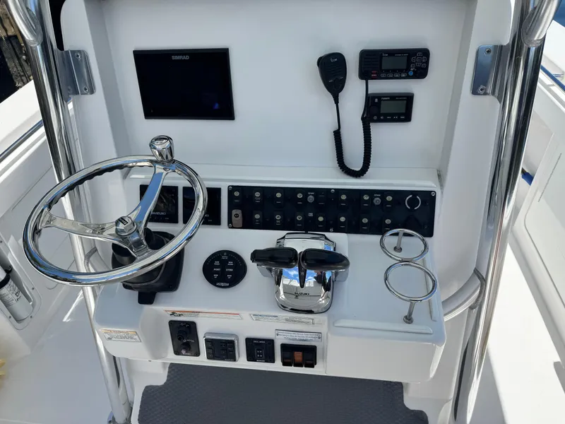 Slide: The Image of 2016 Southport 272TE boat console with steering wheel, controls, and navigation equipment. - 8