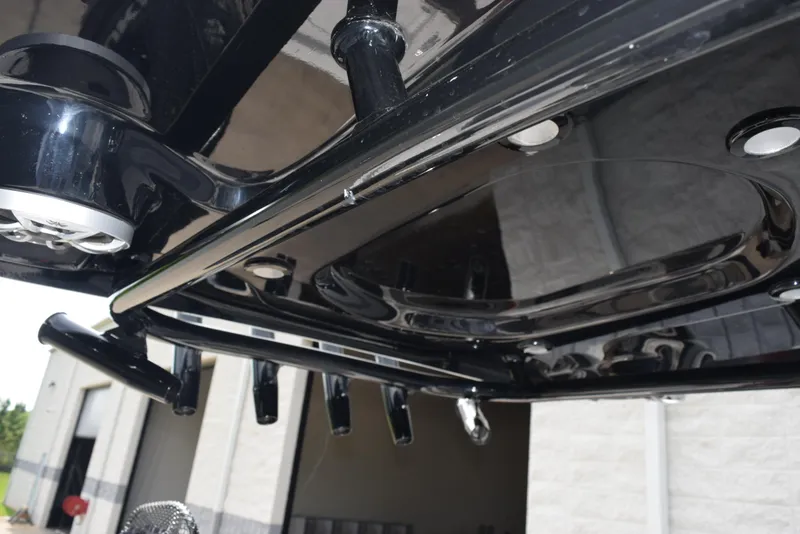 Slide: The Image of 2022 Sea Pro 228 Bay boat's sleek black underside with rod holders and lights. - 11