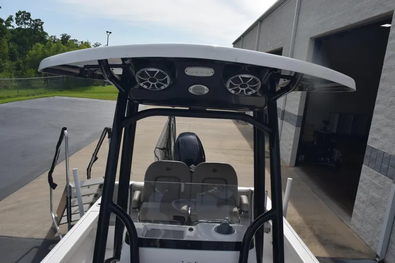 Slide: The Image of 2022 Sea Pro 228 Bay boat with T-top and speakers, parked near a building. - 16