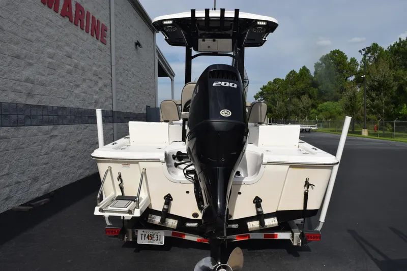 Slide: The Image of 2022 Sea Pro 228 Bay boat with powerful 200 HP engine, parked outside a marine facility. - 5