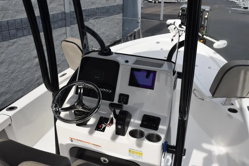 Slide: The Image of 2022 Sea Pro 228 Bay boat dashboard with steering wheel and electronic controls. - 9