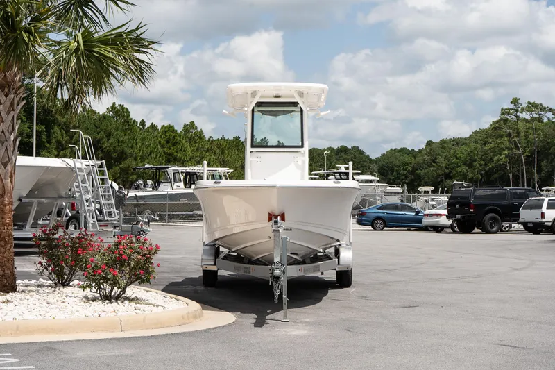 Slide: The Image of 2026 Caymas 24 HB boat on trailer in parking lot, surrounded by trees and vehicles. - 3