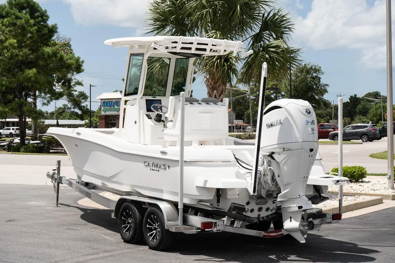 Slide: The Image of 2026 Caymas 24 HB boat with Yamaha engine on trailer, parked outdoors. - 4