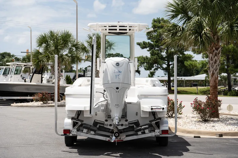 Slide: The Image of 2026 Caymas 24 HB boat on trailer, parked outdoors with palm trees in background. - 5