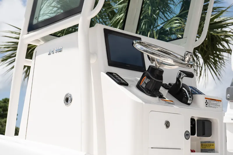 Slide: The Image of 2026 Caymas 24 HB boat console with steering wheel and controls, palm tree background. - 7