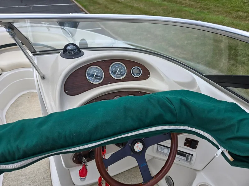 Slide: The Image of Interior of 1998 Chris-Craft 210 Bowrider with beige seating and carpeted floor. - 12