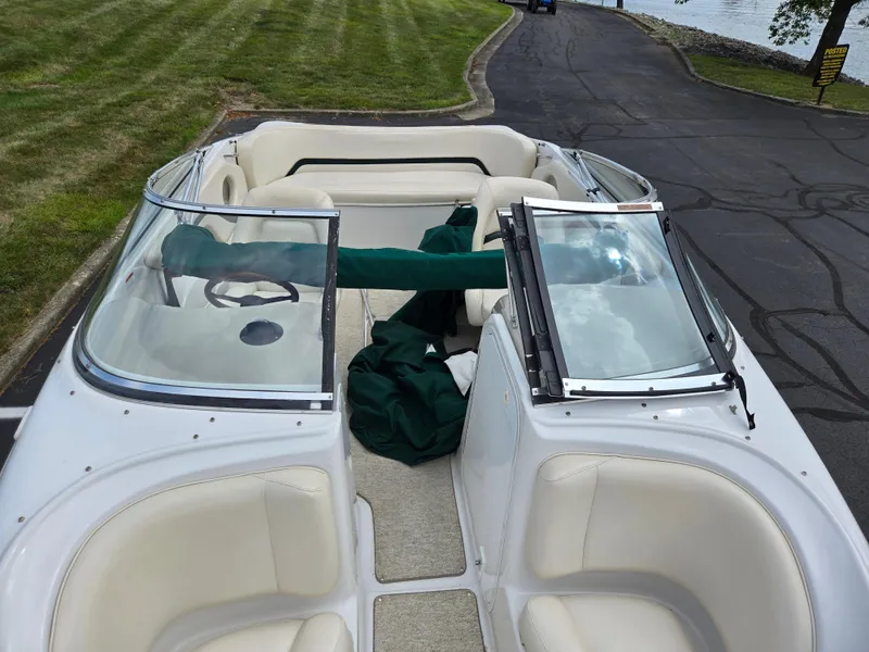 Slide: The Image of 1998 Chris-Craft 210 Bowrider interior with white seating and cup holders. - 19