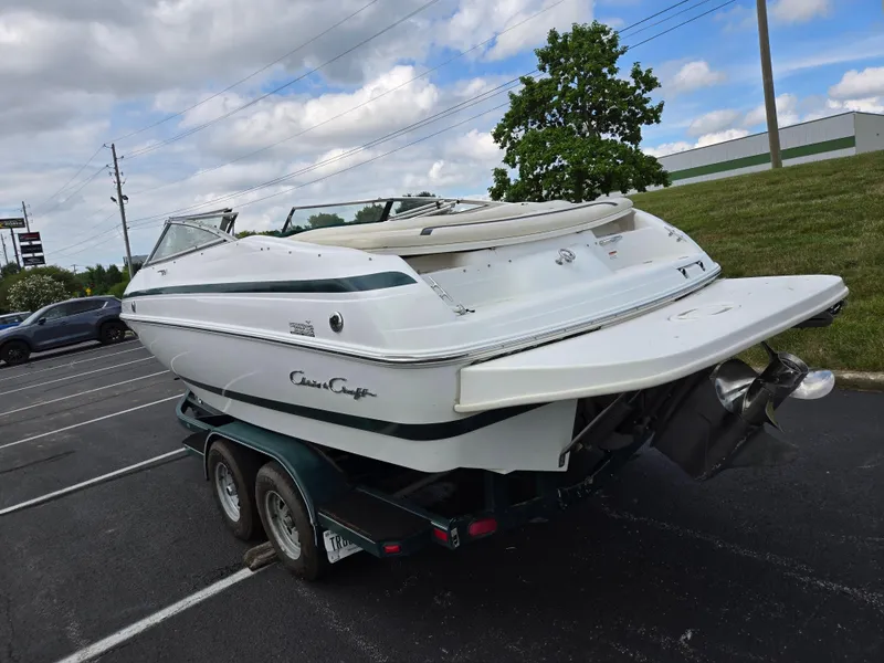 Slide: The Image of 1998 Chris-Craft 210 Bowrider boat on trailer, parked outdoors under blue sky. - 3