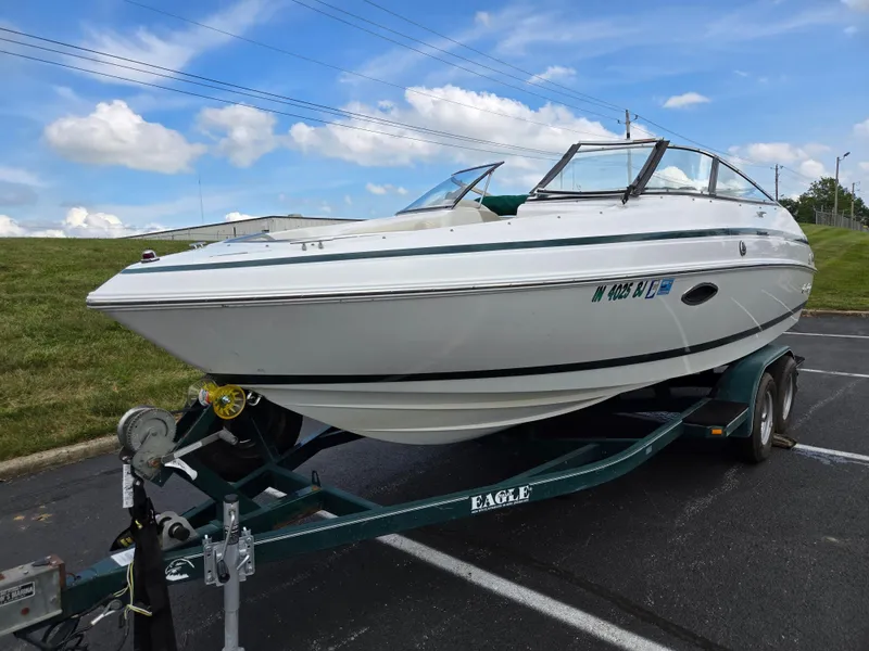 Slide: The Image of 1998 Chris-Craft 210 Bowrider boat on trailer under clear blue sky. - 5
