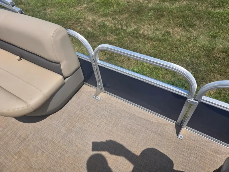 Slide: The Image of 2023 Sun Tracker Bass Buggy 18 DLX pontoon boat interior with beige seating and metal railing. - 11