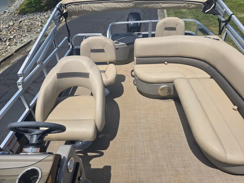 Slide: The Image of 2023 Sun Tracker Bass Buggy 18 DLX pontoon boat with beige seating and steering wheel. - 12