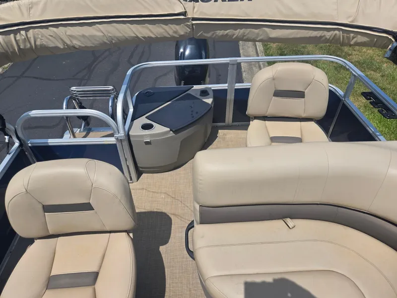 Slide: The Image of 2023 Sun Tracker Bass Buggy 18 DLX pontoon boat interior with beige seating and canopy. - 14