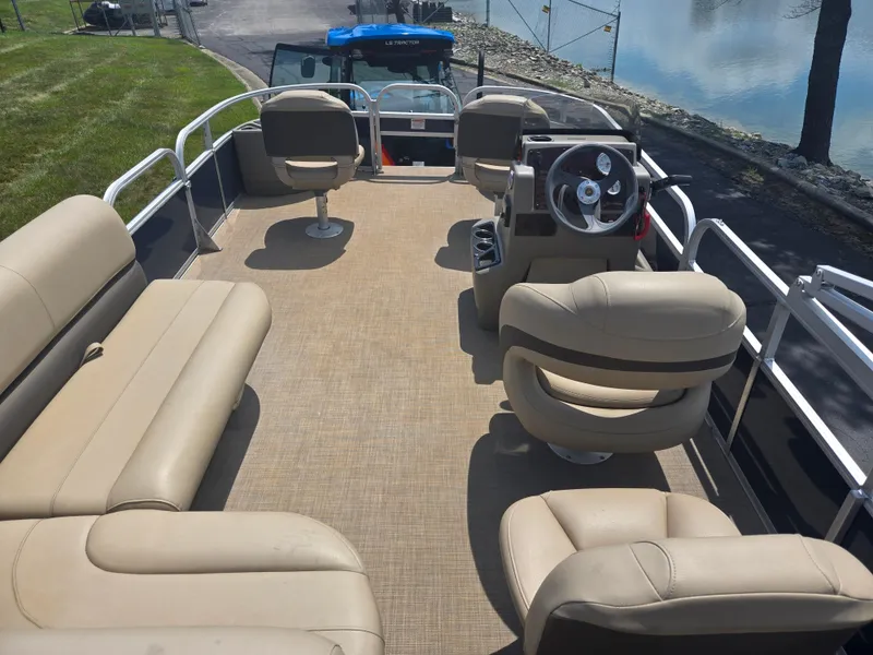 Slide: The Image of 2023 Sun Tracker Bass Buggy 18 DLX pontoon boat interior with beige seating and steering console. - 18