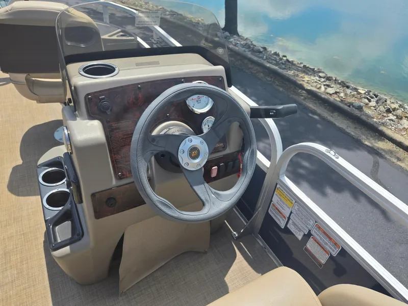 Slide: The Image of 2023 Sun Tracker Bass Buggy 18 DLX steering console with cup holders and gauges. - 19