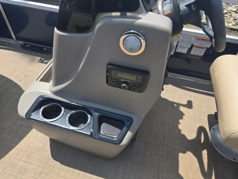 Slide: The Image of 2023 Sun Tracker Bass Buggy 18 DLX console with cup holders and audio controls. - 20