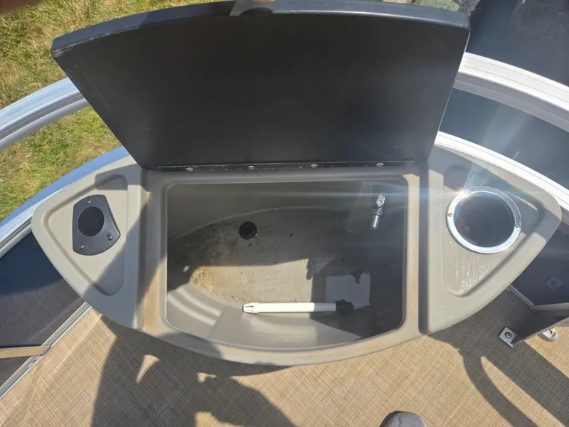 Slide: The Image of 2023 Sun Tracker Bass Buggy 18 DLX livewell with open lid and cup holder. - 22