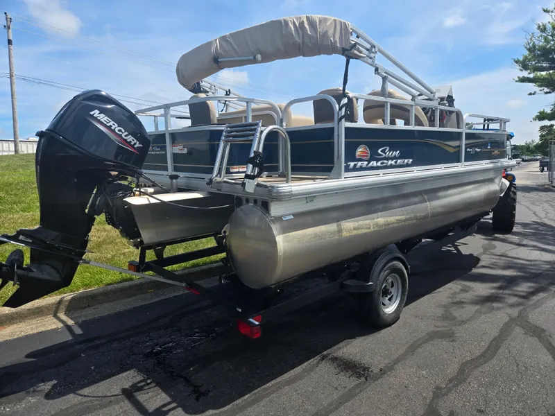 Slide: The Image of 2023 Sun Tracker Bass Buggy 18 DLX pontoon boat on trailer, featuring Mercury outboard motor. - 3