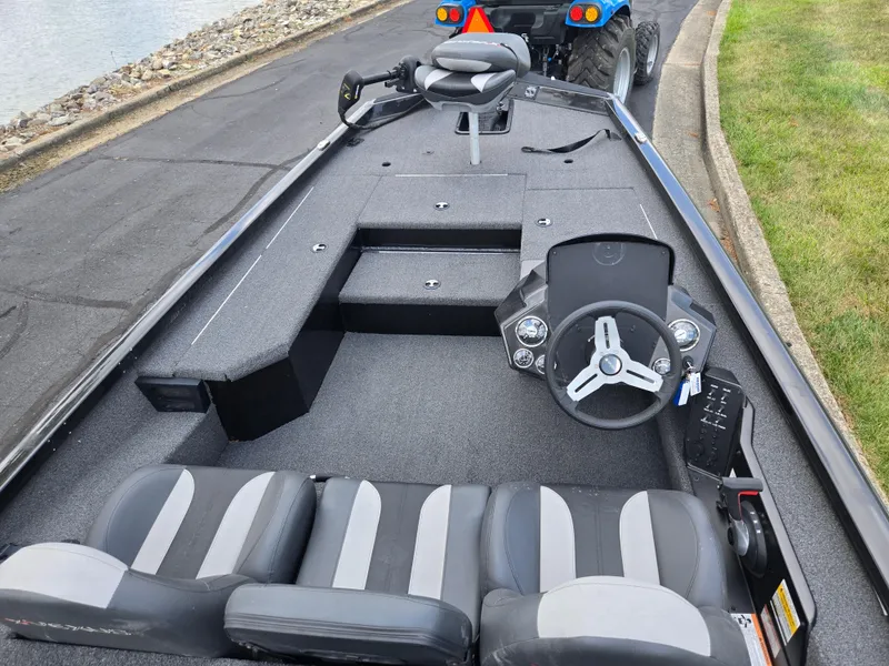 Slide: The Image of 2022 Vexus AVX181 boat interior with steering wheel and seating, parked near water. - 12