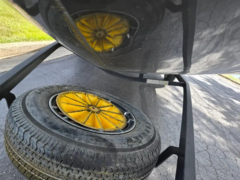 Slide: The Image of 2022 Vexus AVX181 boat trailer with spare tire and yellow wheel hub on pavement. - 8