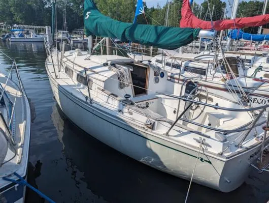 The Image of 1979 Sabre 28-2 sailboat docked, featuring green and red sails, in a marina setting. - 0